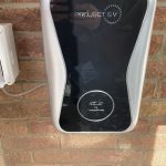 Brick wall of bungalow with mounted EV charging point