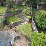 Narrow rear garden with terraced lawn areas, paving and planting