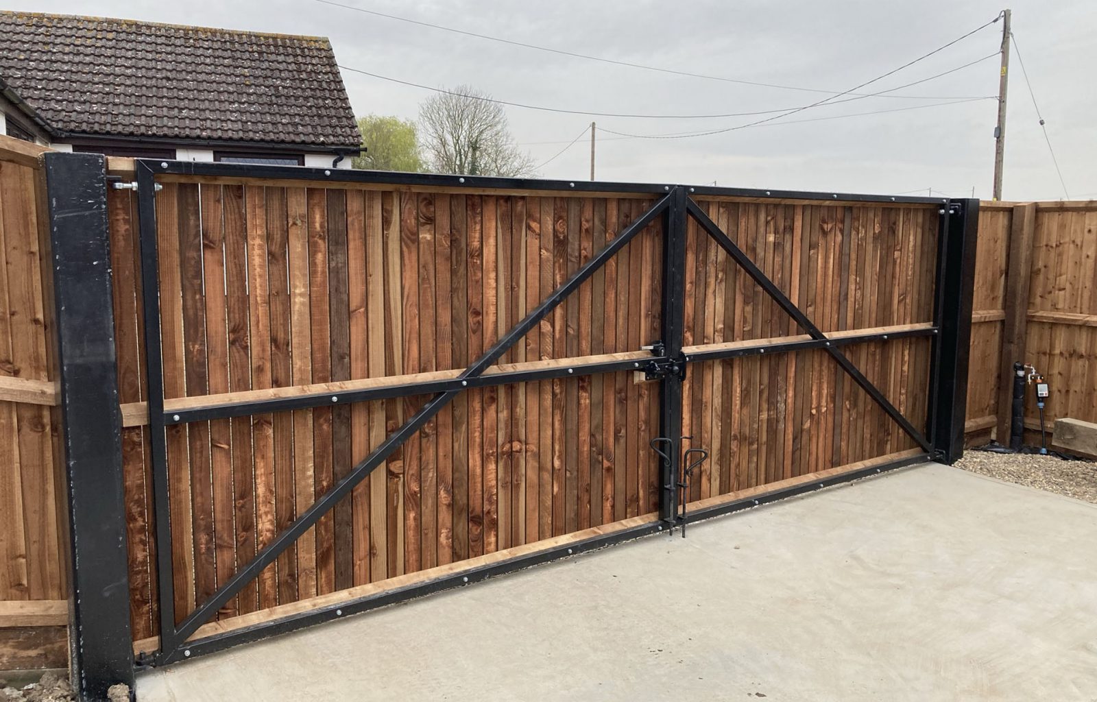 Close board wooden double gates on metal frame to enclose rear garden entrance