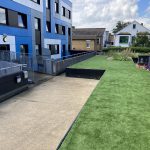 Raised lawn and planters outside entrance to a University building